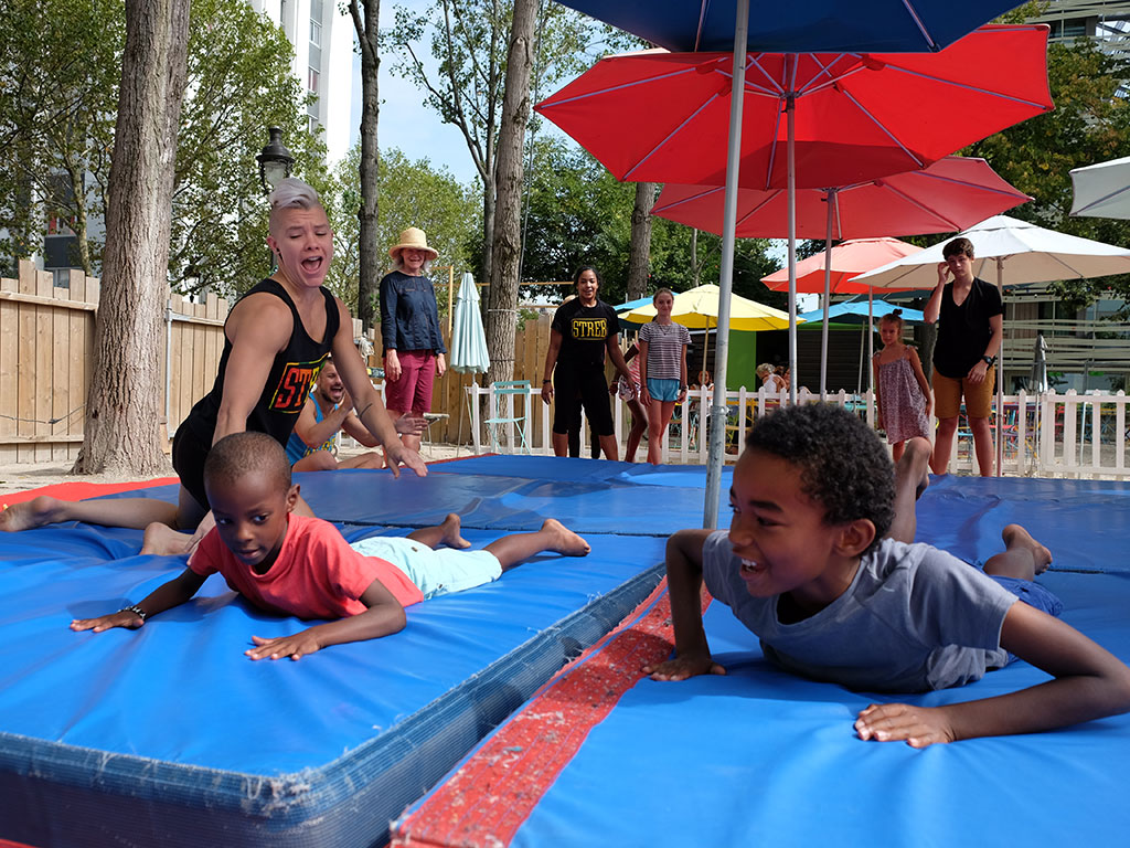 Des enfants atterrissent sur des tapis en plein air