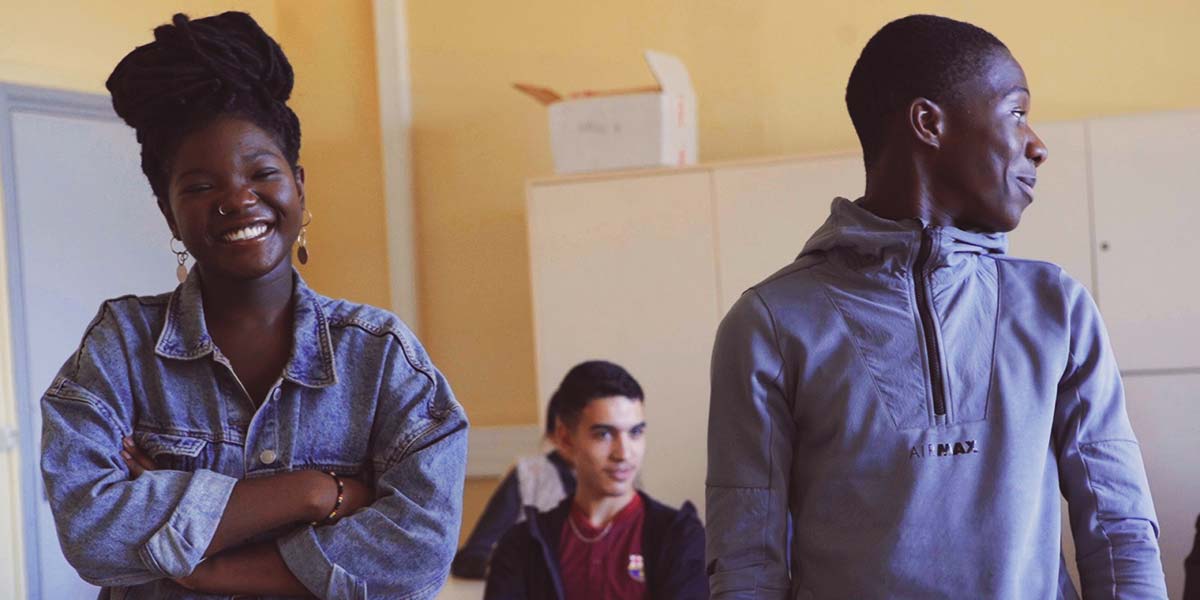 Deux adolescents souriants dans une salle de classe