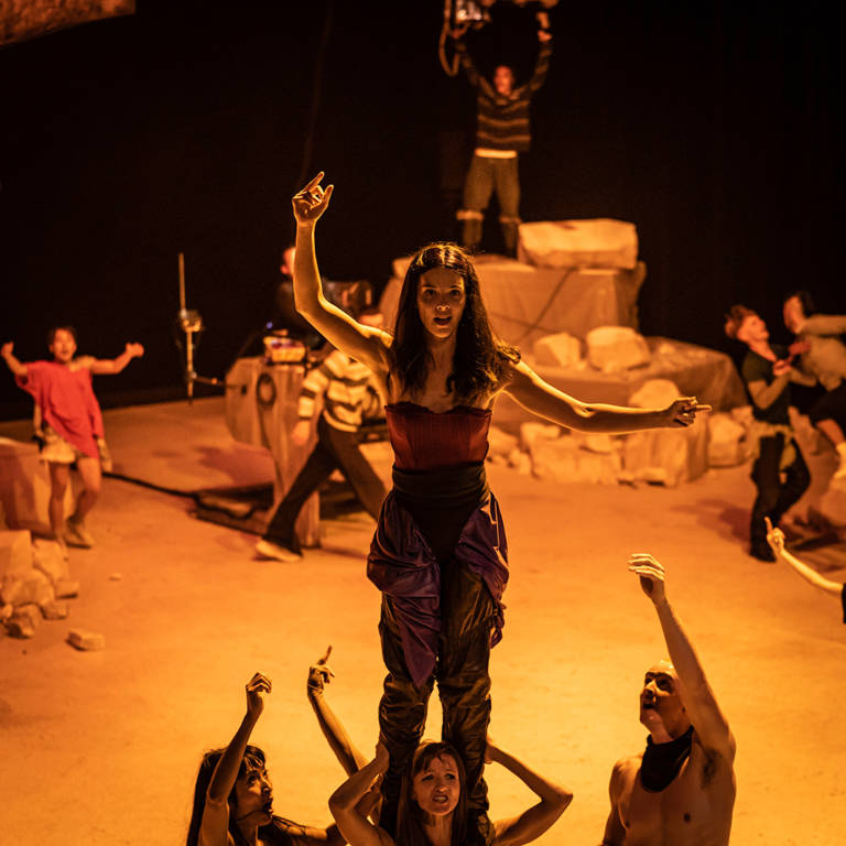 une danseuse est debout sur les épaule d'une autre danseuse