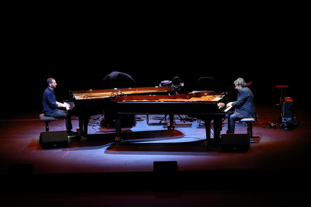 Deuxc pianistes jouant sur deux pianos à queue face à face
