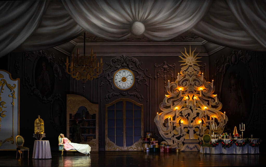 Une femme allongée sur une méridienne dans un salon avec un arbre de Noël illuminé