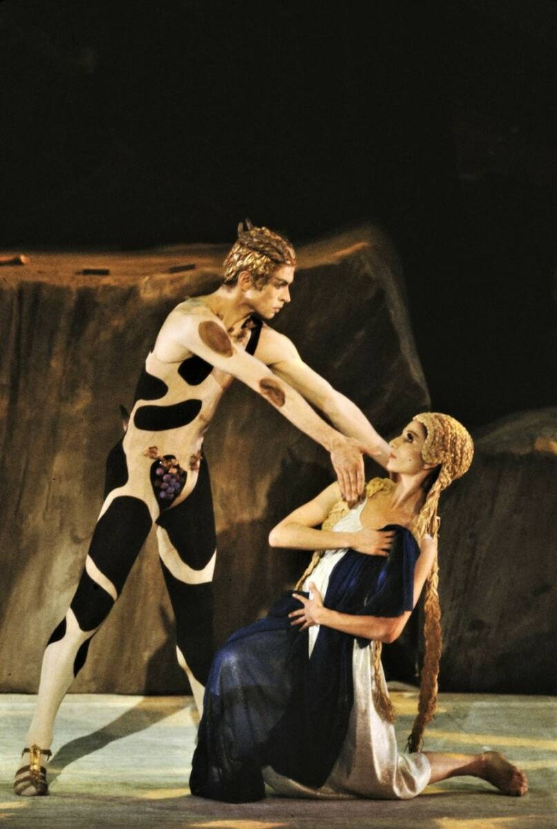 Un danseur en tenue d'animal surplombe une danseuses, 