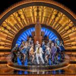 Une troupe de danseurs en tenue des années 20 sur un podium doré